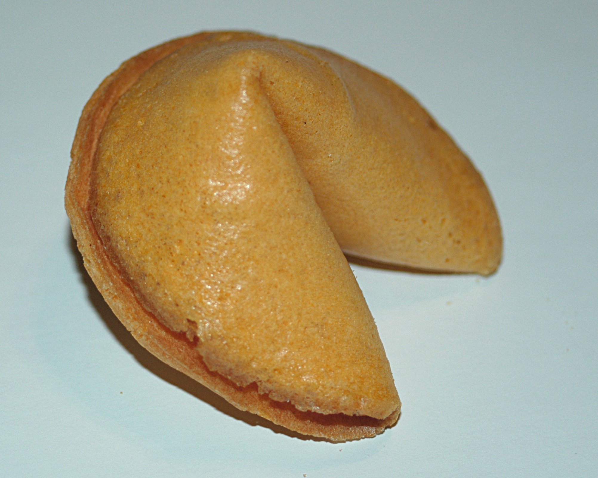 A whole fortune cookie on a white background